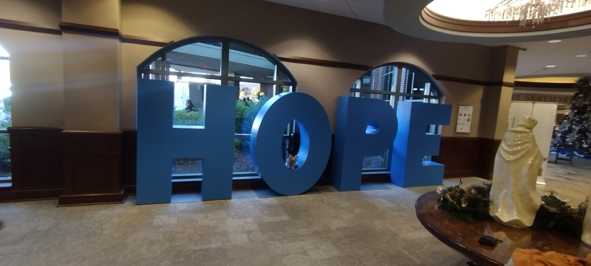 Large blue letters spelling HOPE displayed in a community center lobby